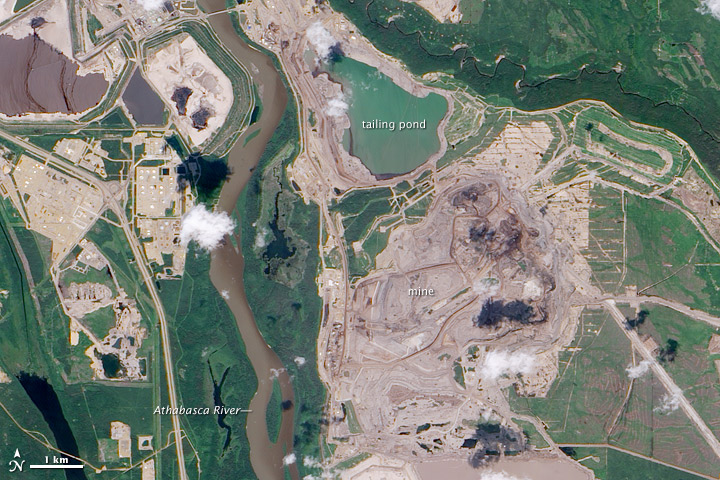 A satellite image of the Athabasca oil sands beside the Athabasca River. The oil sands include the mine and tailing pond.